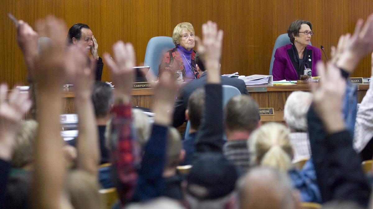 San Luis Obispo City Council members Dan Carpenter, Kathy Smith and Mayor Jan Marx look at the overflow crowd waving in support of a pro-medical marijuana comment. About 150 turned out for a proposed ordinance on regulating medical marijuana.
