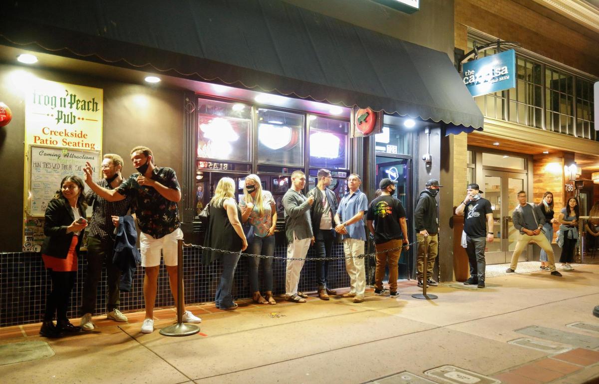 Patrons wait in a long line in downtown SLO in June. SLO is among two cities in the county to issue COVID-19 order citations thus far.