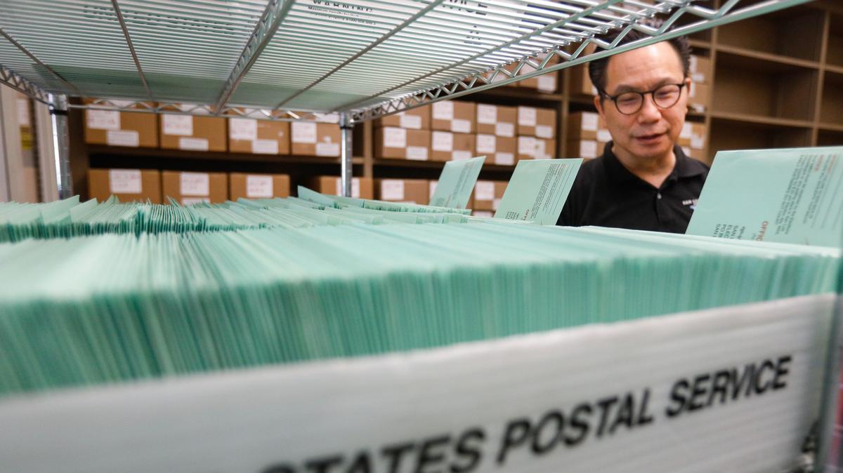 San Luis Obispo County Clerk-Recorder Tommy Gong looks over trays filled with vote-by-mail ballots. Some local Republicans believe mail-in voting should be limited to people with medical conditions.