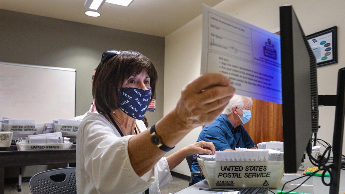 Jane Baker, temporary election assistant, verifies signatures on ballot envelopes by comparing them to a digital record ahead of the November 2020 election.