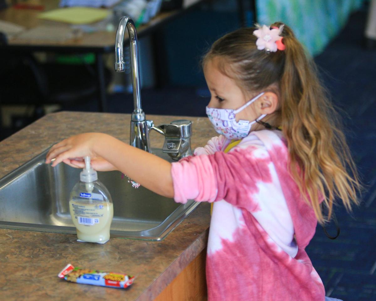 Teacher Shelby West greets her transitional kindergarten kids back to Shell Beach Elementary School. Taj Oakley washes before starting class time.