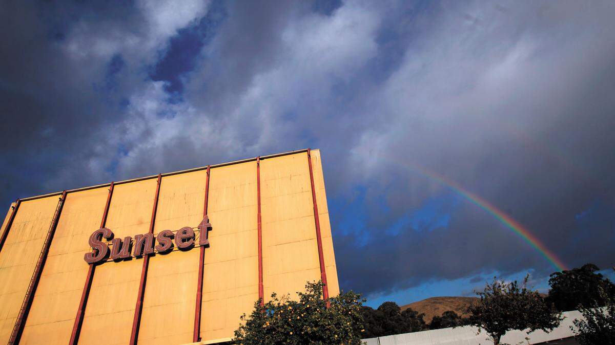 A rainbow arcs across cloudy skies over Sunset Drive-in on an autumn afternoon in San Luis Obispo.