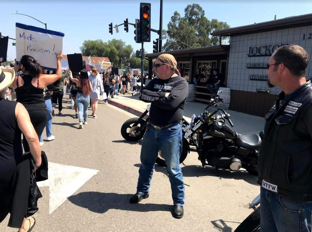 Motorcyclists, including at least one man wearing a Gold Coast Wheelers vest, stand outside Jocko’s Steakhouse in Nipomo during an anti-racism protest on Thursday.