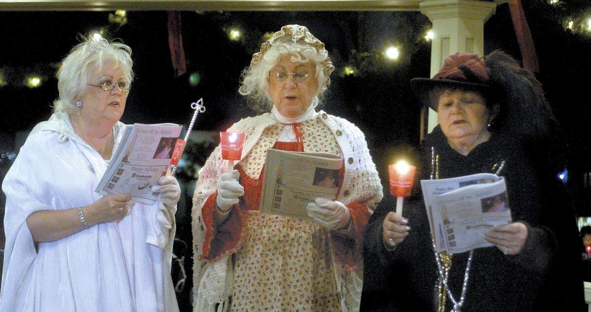 The Snow Queen (Millie Drum) and Mrs. Santa Claus (Barbara Wilcox) and Norma Moye of the Paso Robles Main Street Association sing Christmas carols in the City Park gazebo after the tree lighting ceremony Nov. 25, 2005.