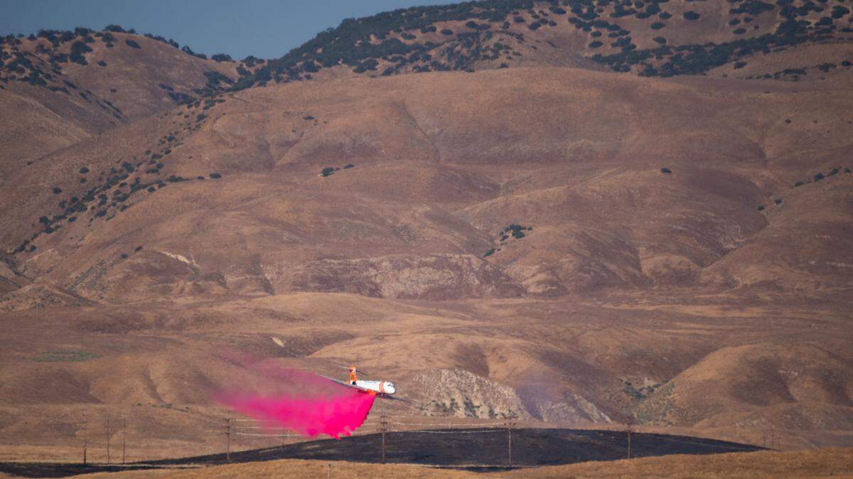 A plane drops retardant on a brush fire on the Carrizo Plain on June 28, 2023.