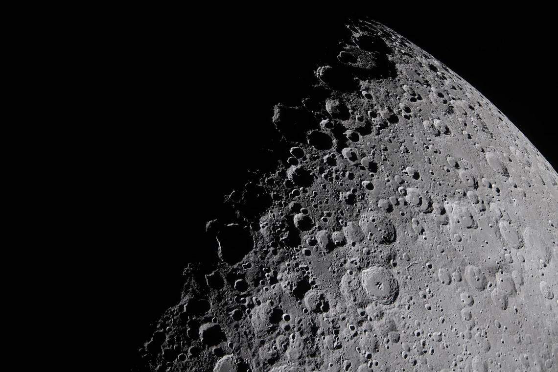The Artemis II crew captures a portion of the moon coming into view along the terminator — the boundary between lunar day and night — where low-angle sunlight casts long, dramatic shadows across the surface, during the lunar flyby on April 6, 2026.