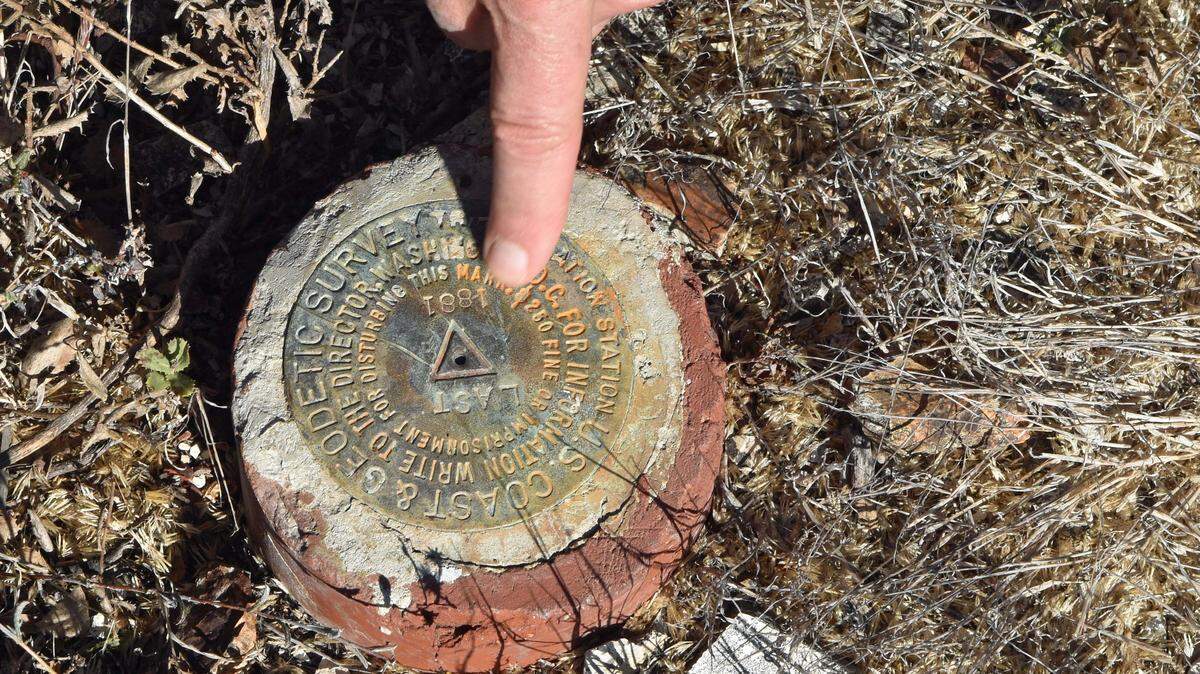 Survey monuments are mostly 3-inch cast metal disks affixed to the tops of pipes that have been pounded into the ground or fastened on large rocks or concrete pillars. A legend is usually stamped on their faces. This 1881 survey marker was installed in 1881 on top of the Irish Hills on the Diablo Canyon Lands along the Pecho Coast.