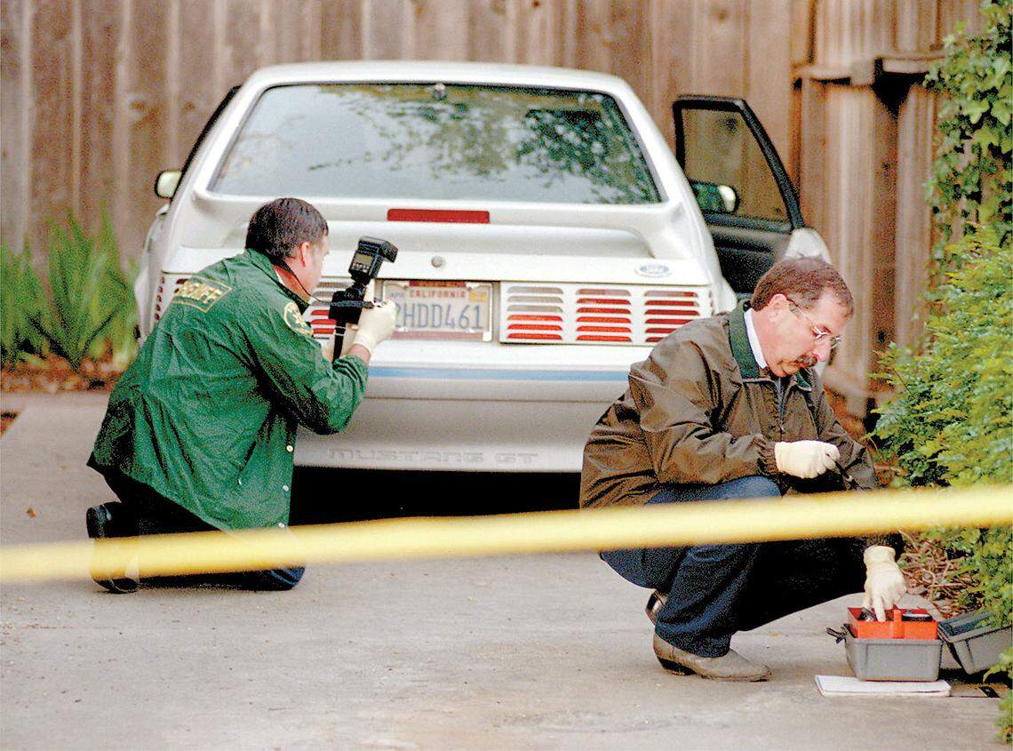 Technicians from the San Luis Obispo County Sheriff’s Office gather evidence in the driveway of Aundria Crawford’s Branch Street home in San Luis Obispo on March 12, 1999.