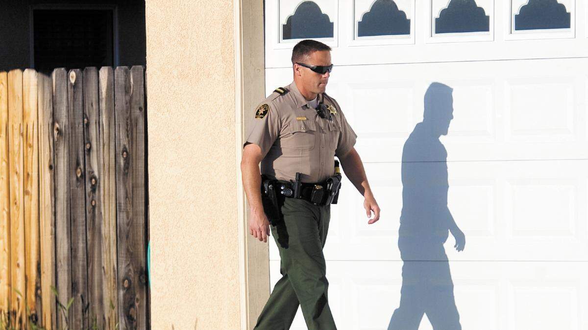 Sheriff’s Deputy Neil Clayton investigates a burglary alarm call in San Miguel in April. When he walked the perimeter, he heard dogs inside the house, which may have set off the alarm. The house checked out secure.