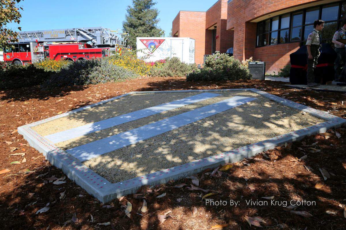 The memorial features a 140-square-foot concrete pentagon set into the hillside in front of the fire station. The border is inlaid with 344 red tiles for firefighters, 60 blue for police and eight white for EMT personnel. It includes two porcelain rectangular shapes inside, representing the Twin Towers, and a steel fragment from the wreckage, owned by Five Cities Fire Authority.