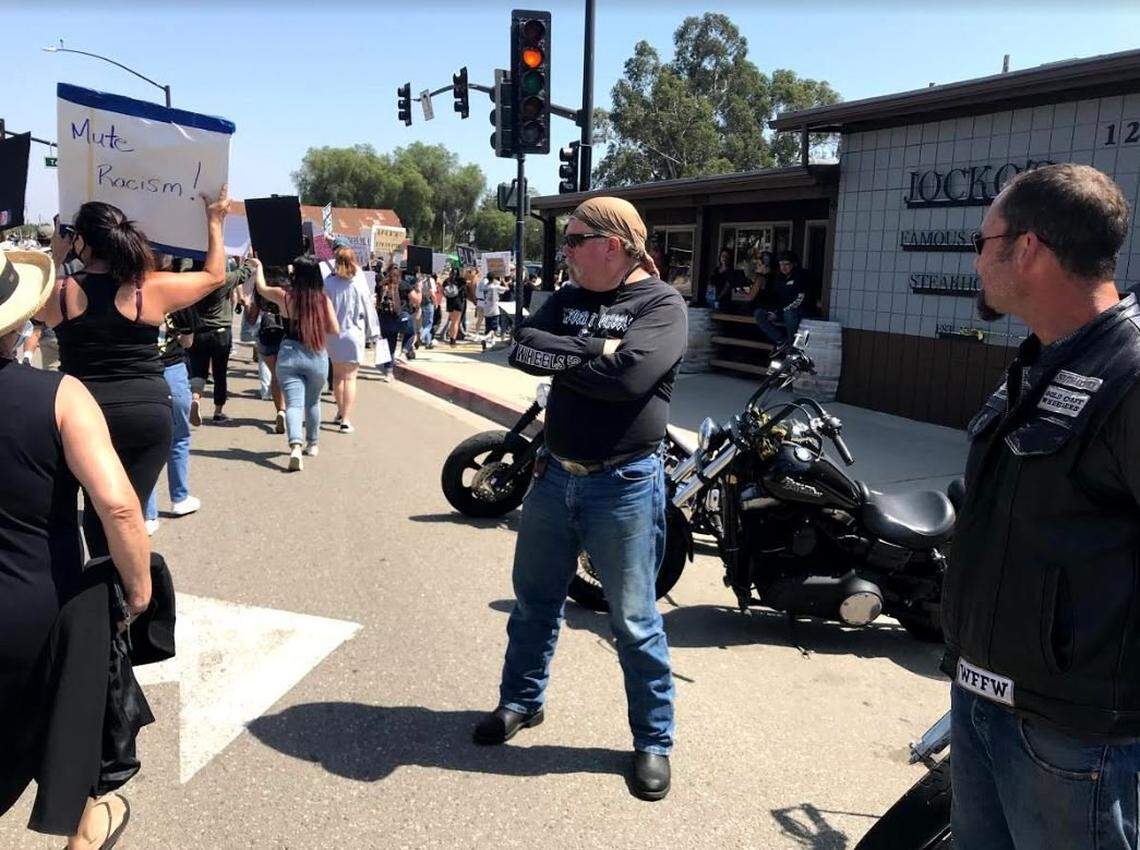 Motorcyclists, including at least one man wearing a Gold Coast Wheelers vest, stand outside Jocko’s Steakhouse in Nipomo during an anti-racism protest.