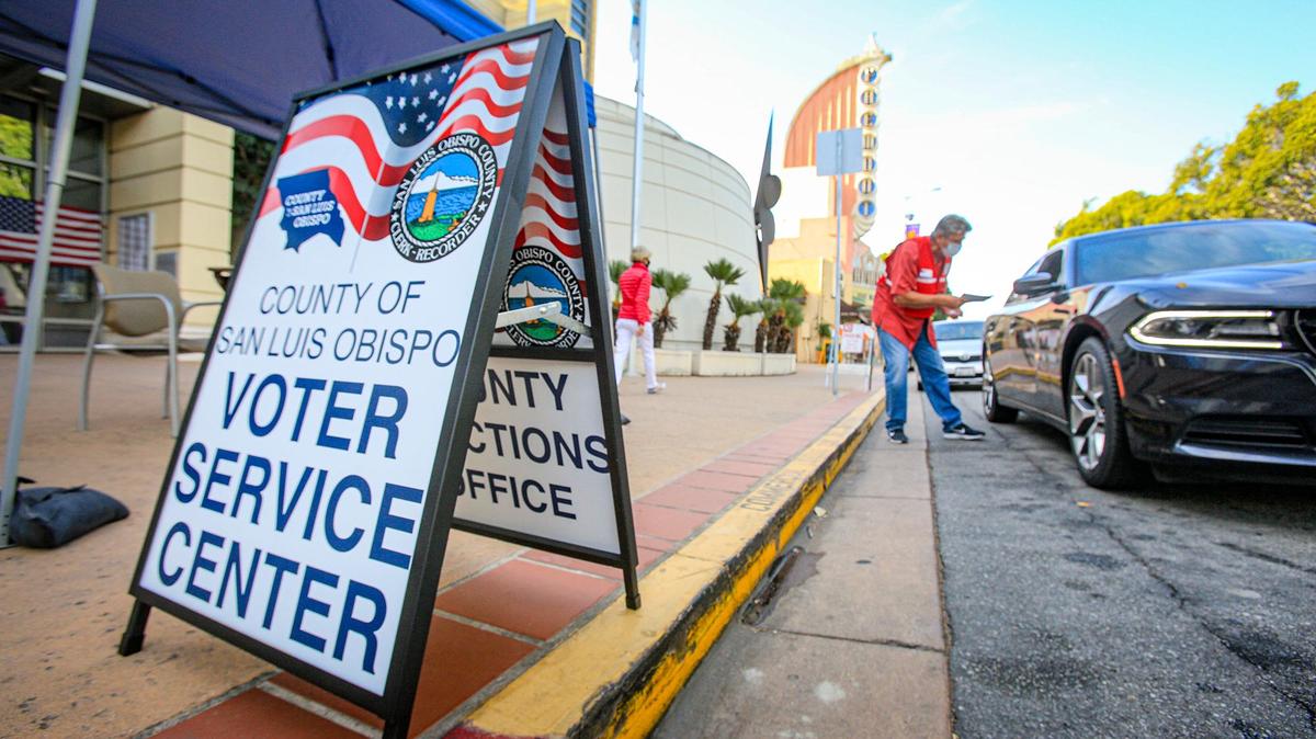 Hundreds of mail-in ballots were collected at the drop box in front of the San Luis Obispo County Government Center on Tuesday morning. Temporary election worker George Fisher made sure the envelopes were signed before the ballots were placed in the box.