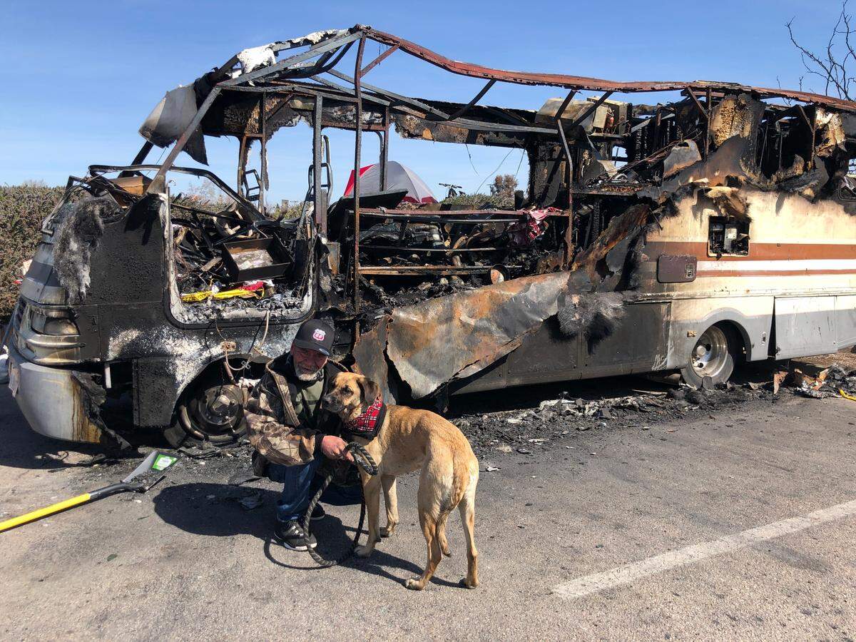 Billy Tosch, 63, with his dog Sadie, 2, in front of his burned RV in the Paso Robles Walmart parking lot. Tosch’s story of loss took a heartwarming turn when he received a gift motor home from Hugh Robinson of Nipomo.