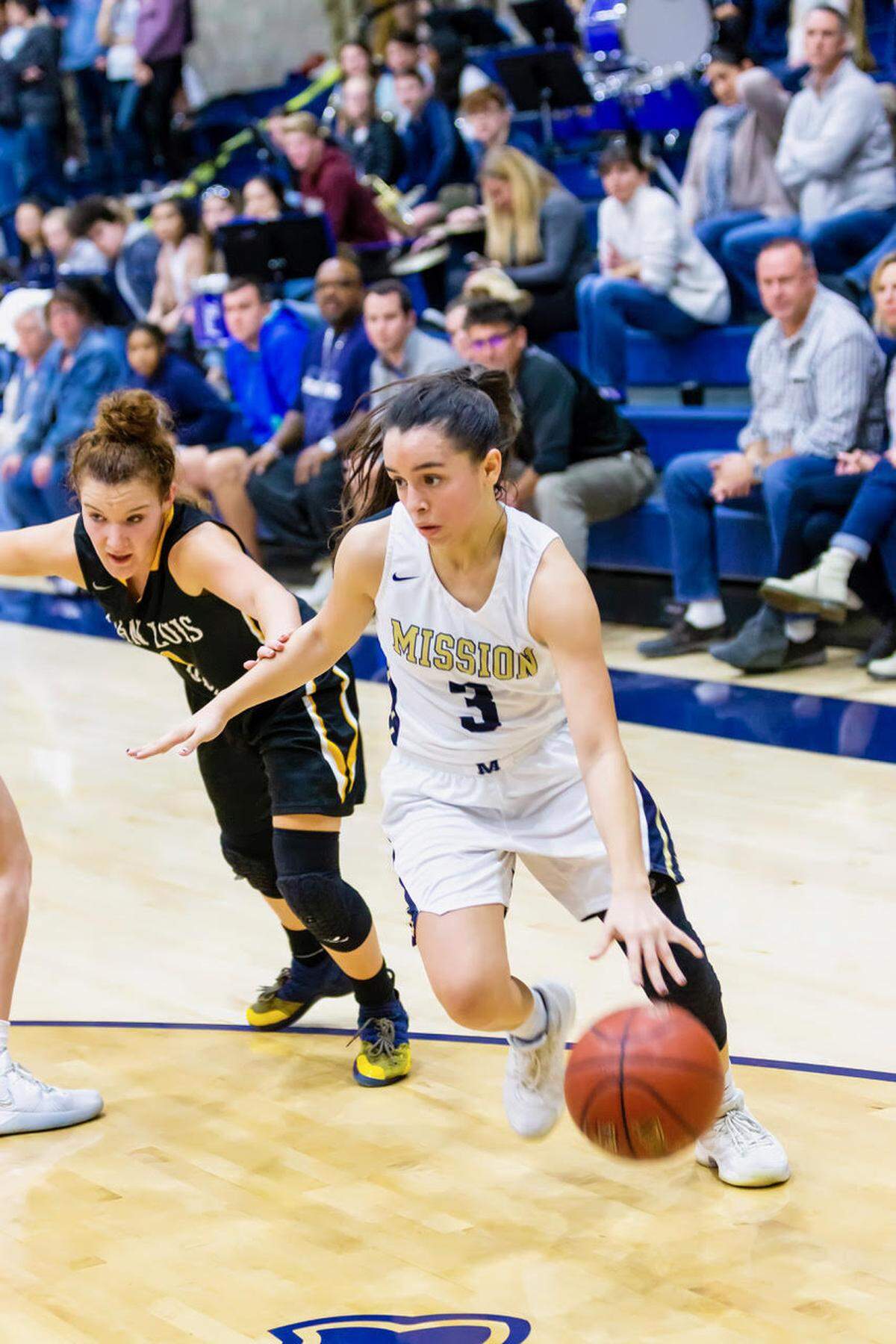 Mission Prep guard Ary Gonzales drives around San Luis Obispo High School defender Anika Meyer in the teams’ Jan. 11 game.