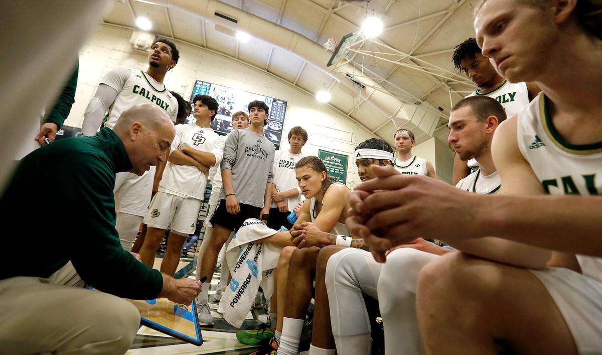 Cal Poly Head Coach Mike DeGeorge briefs his players on the sidelines. The Mustangs won 98-72 against Cal State Bakersfield, Saturday, March 1, 2025 at Mott Athletics Center.