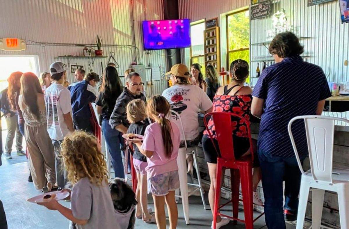 Customers gather inside Tin City Cider Co. in Paso Robles on May 23, 2026, after the business announced plans to close its tap house later this month after nearly a decade in Tin City.