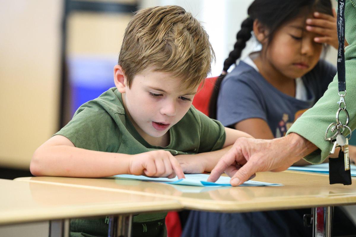 First-graders Oliver Hootman and Eva Jimenez Flores practice reading word by word at Carrisa Plains Elementary School with help from Jani Klasfeld, in September 2023.