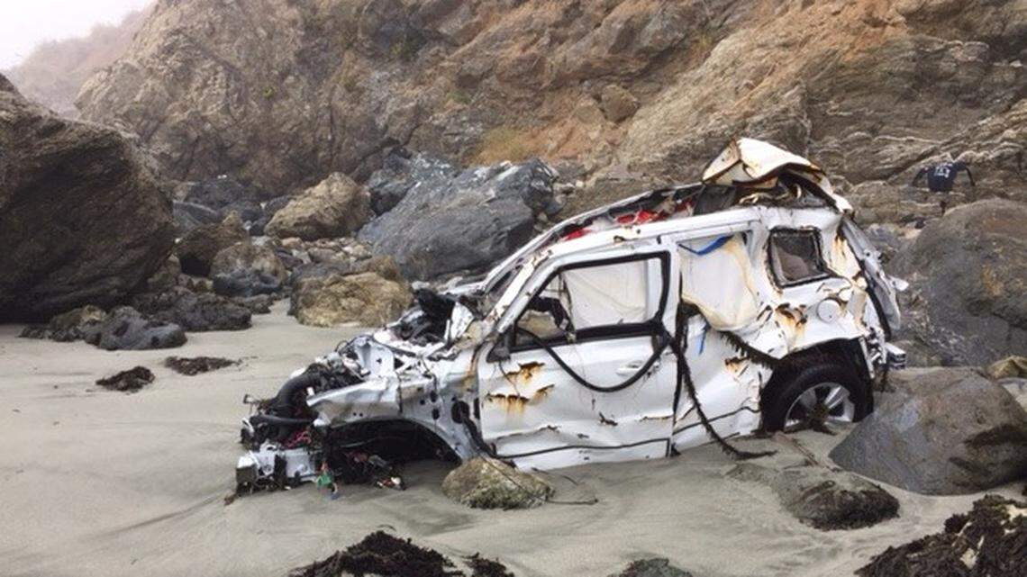 The wreck of Angela Hernandez's white 2011 Jeep Patriot rests in the water line Friday on a rocky Big Sur beach.