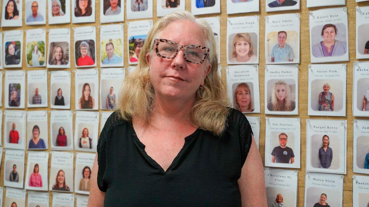 Marina Bernheimer, executive director of the San Luis Obispo branch of the Court Appointed Special Advocates for Children, or CASA, stands in front of a wall of pictures of CASA volunteers on Tuesday, May 12, 2026. CASA is facing a 25% budget reduction in its annual budget following a slew of federal, state and county budget cuts.
