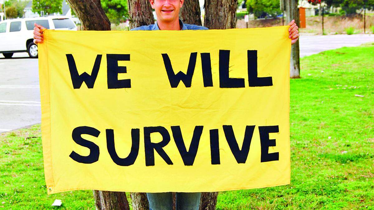 Boy Scout Austin Gasbarra, 15, of Troop 413 in Arroyo Grande holds the troop’s new yellow ‘We Will Survive’ sign.