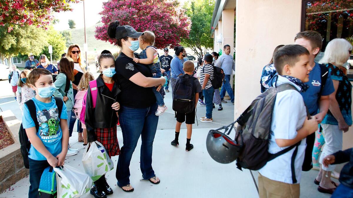 Atascadero Unified School District welcomed students back Wednesday to full, in-person classes for the 2021-22 school year. At left, Charley Griffin carries Daisy, 1, as Orion, 7, far left, and Ireland, 9, center, arrive on campus at San Gabriel Elementary.
