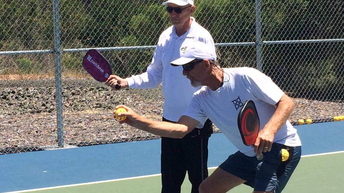 Cambria professional pickleball instructor Gregg Whitfield, right, offers tutoring to Bill Shepherd at the Cambria Pickleball Courts.