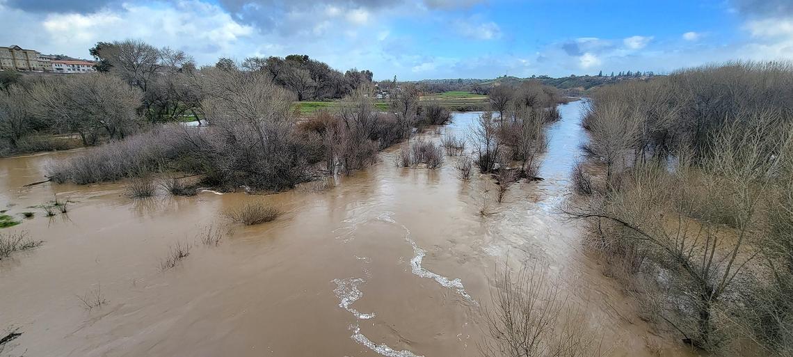 A swollen Salinas River flows under the the Niblick Bridge in Paso Robles on Thursday, Jan. 5, 2023, the morning after a “bomb cyclone” storm hit San Luis Obispo County.