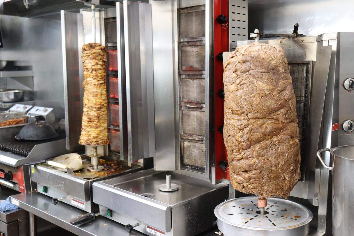 Rotisseries of chicken and tri-tip gyro meat slow cook in Petra’s kitchen.