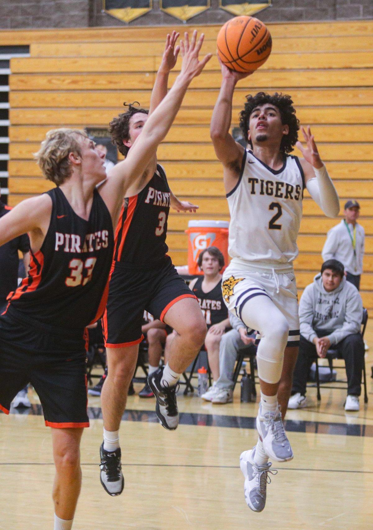 Jaden Pooler (2) shoots while Landon Lassahn (33) and Jackson Ollenburger (3) defend in San Luis Obispo’s 63-51 win over Santa Ynez in a boy’s basketball game on Jan. 20, 2023.