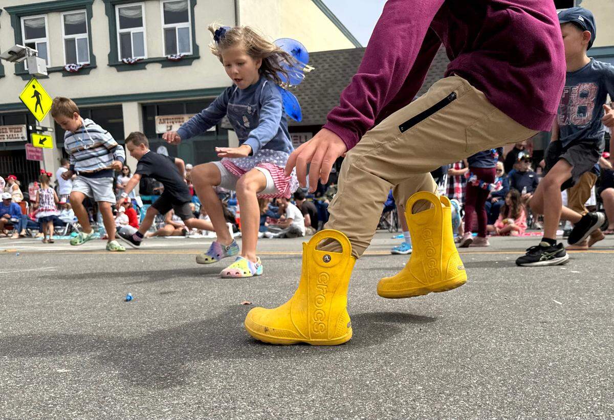 Kids scramble for candy thrown from parade floats at the Fourth of July parade in Cayucos, California. 
