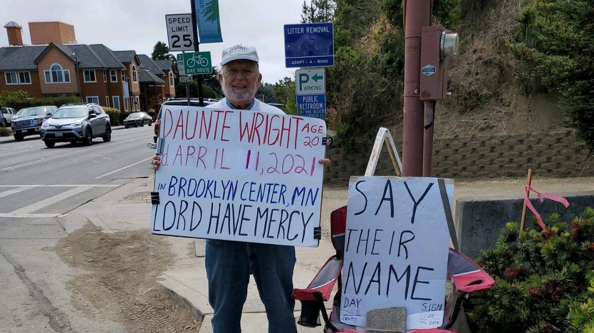 The Rev. Don Dallman stands vigil on July 12, holding a sign with the name of one of more than 45 people of color who were killed by law enforcers or armed citizens, most of them white. By early September, he’d stood near the intersection of Burton Drive and Main Street in Cambria for more than 160 days.