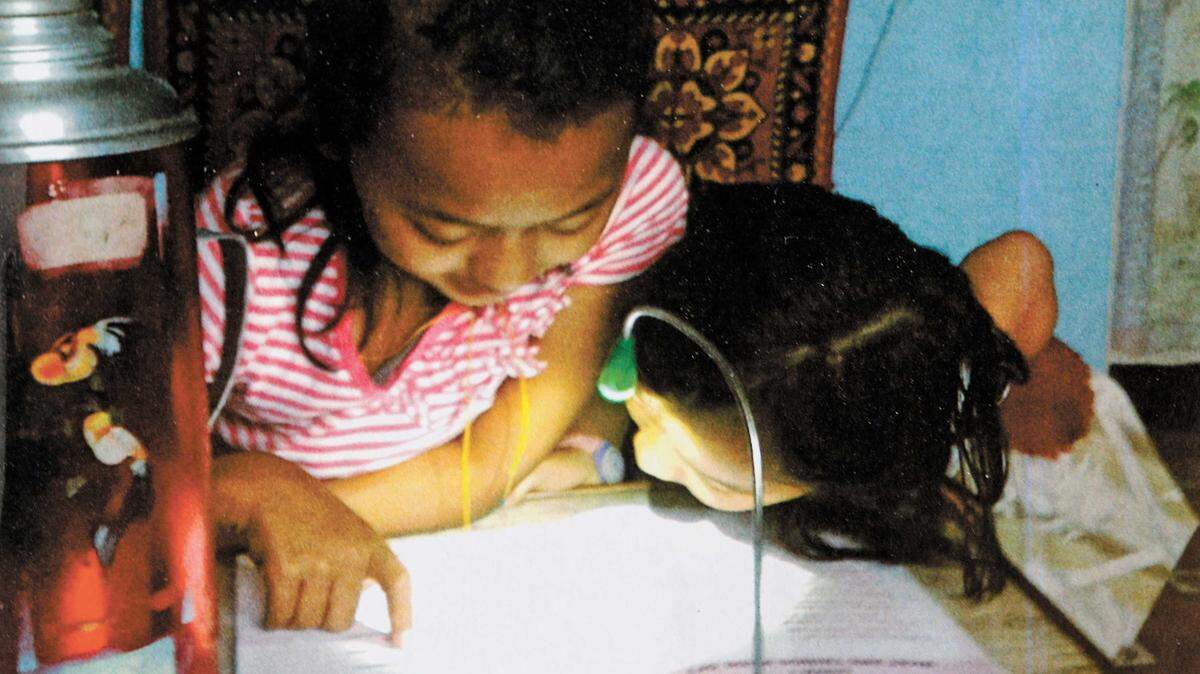 Children read by solar light in a rural village in Nepal.