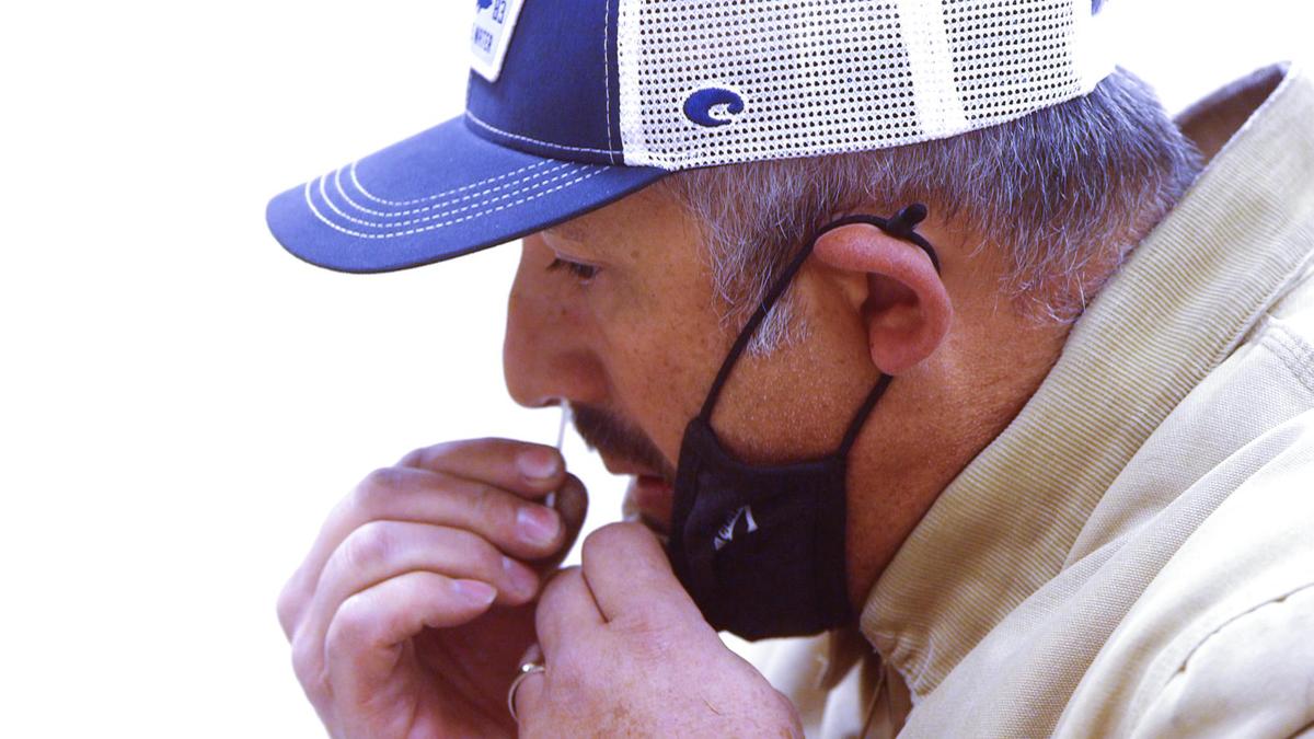 Micky Hedger of Atascadero self-administers a test at the San Luis Obispo County Health Department’s popup site at the Atascadero Lake Pavilion on Dec. 30, 2021. About 60 tests per hour were administered as concern over the rapid spread of the omicron variant grows.
