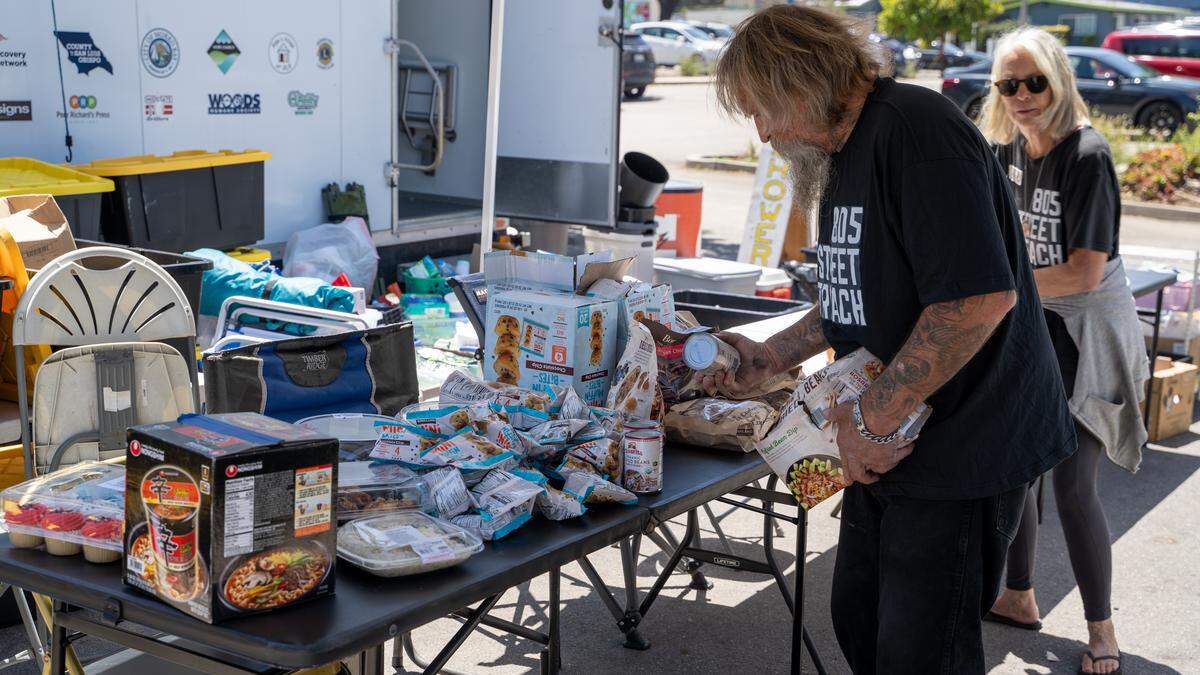 805 Street Outreach volunteers lay out free non-perishable food in the parking lot of the Morro Bay Library on Monday, May 18, 2026. The organization has grown quickly since its founding in 2024 and offers showers, laundry and food to homeless Morro Bay residents.