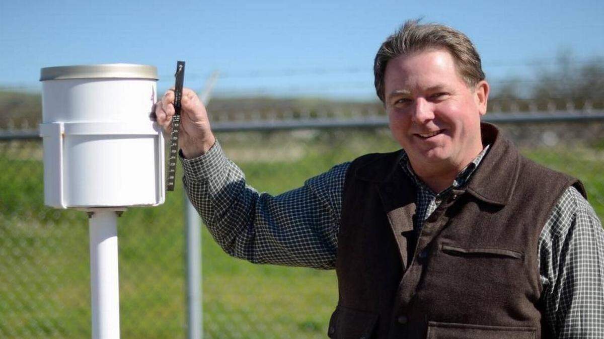 PG&E meteorologist John Lindsey took this photo of Atascadero Mutual Water Company manager John Neil by the Salinas River and the company’s rain gauge.