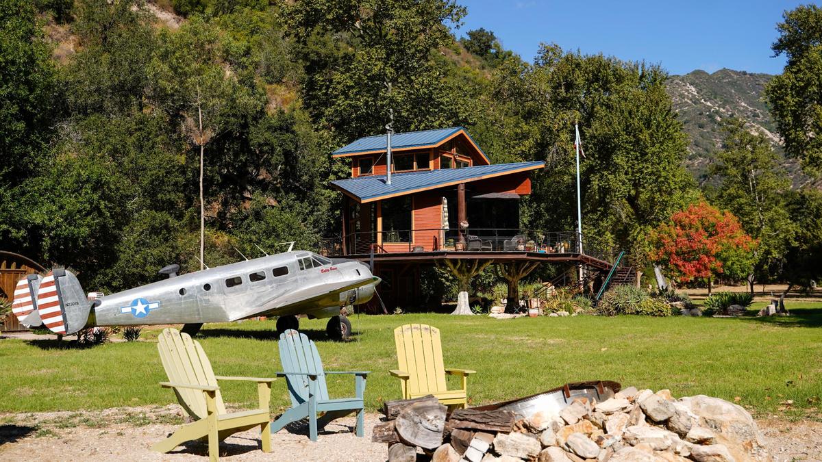 Longtime former San Luis Obispo County resident Reggie Whibley’s home north of Lopez Lake is a tree-house-like structure built on metal legs painted to resemble trees Tuesday, Oct. 29, 2024. Following Whibley’s death in 2020, the property went up for sale, featuring views of the surrounding canyon, custom woodworking and design and a fully converted Beachcraft airplane parked in the backyard, which serves as the guest lodging.