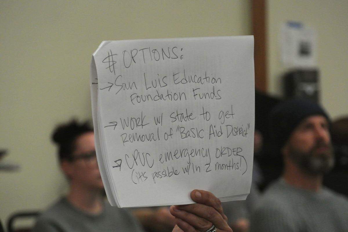 SLO resident and parent Lucia Stone held up a sign with her funding suggestions to prevent the possible closure of transitional kindergarten programs in the San Luis Coastal school district Jan. 14, 2025.