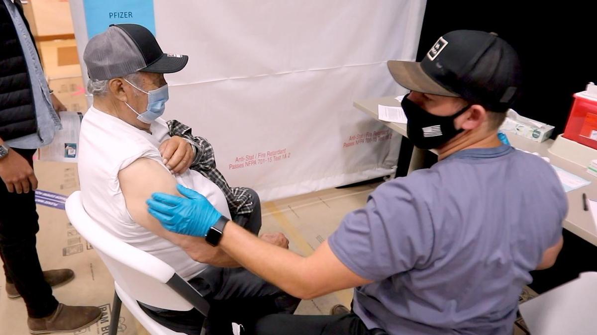 Jacob Gonzales Sanchez of Nipomo receives a COVID-19 vaccination from Taylor Gomes, a paramedic with the SNAP Nurse program who has traveled to San Luis Obispo to help administer coronavirus vaccines at county sites.