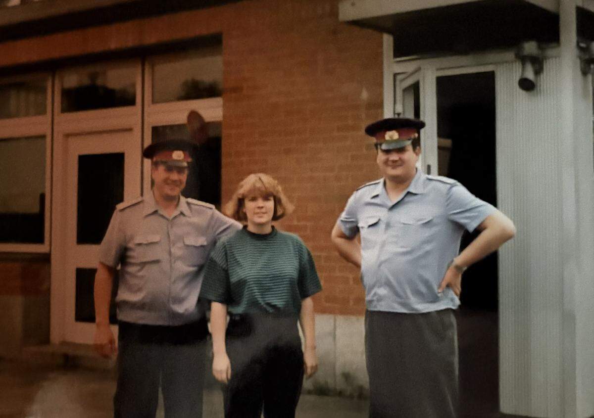 Susan Miller, now a retired CIA agent, poses with uniformed KGB guards in Moscow while working undercover as a spy for the CIA in 1989. Miller graduated from Cal Poly.