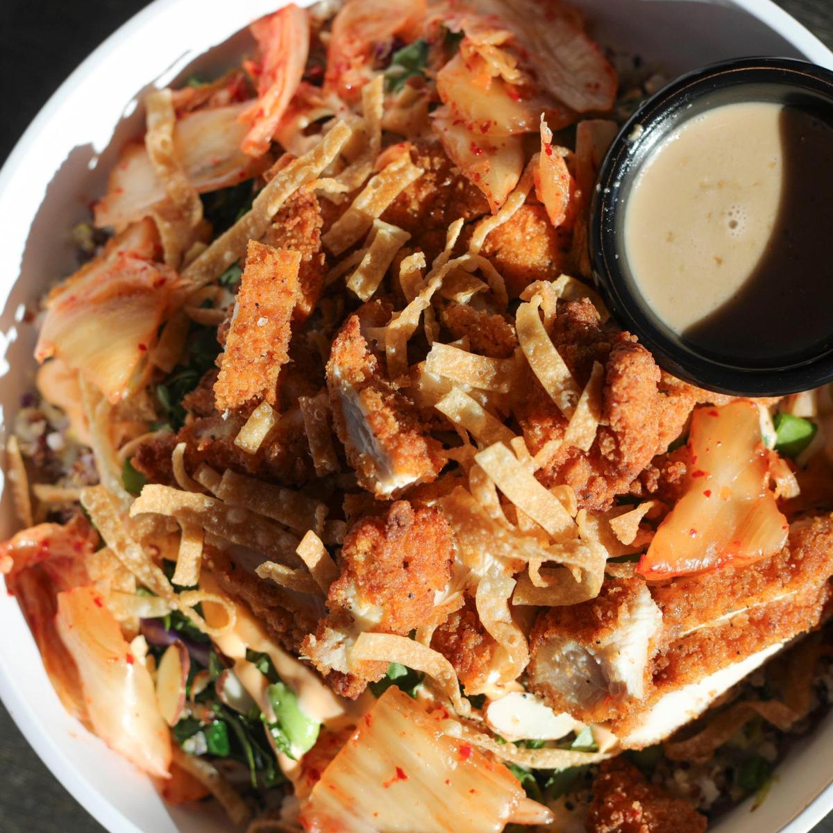 Morro Grill’s Asian Power Bowl with crispy chicken, topped with carrots, toasted almonds, wonton strips, edamame, green onions, kimchi, cilantro and spicy mayo. It’s served with ginger-soy vinaigrette at the new eatery on the Embarcadero on Feb. 9, 2024.