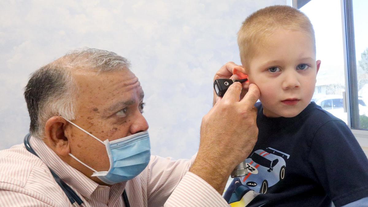 Dr. Rene Bravo gives a standard wellness check to Landon Aanerud, 4, on Jan. 26, 2022. Bravo urges anyone who is eligible to get the COVID-19 vaccine.