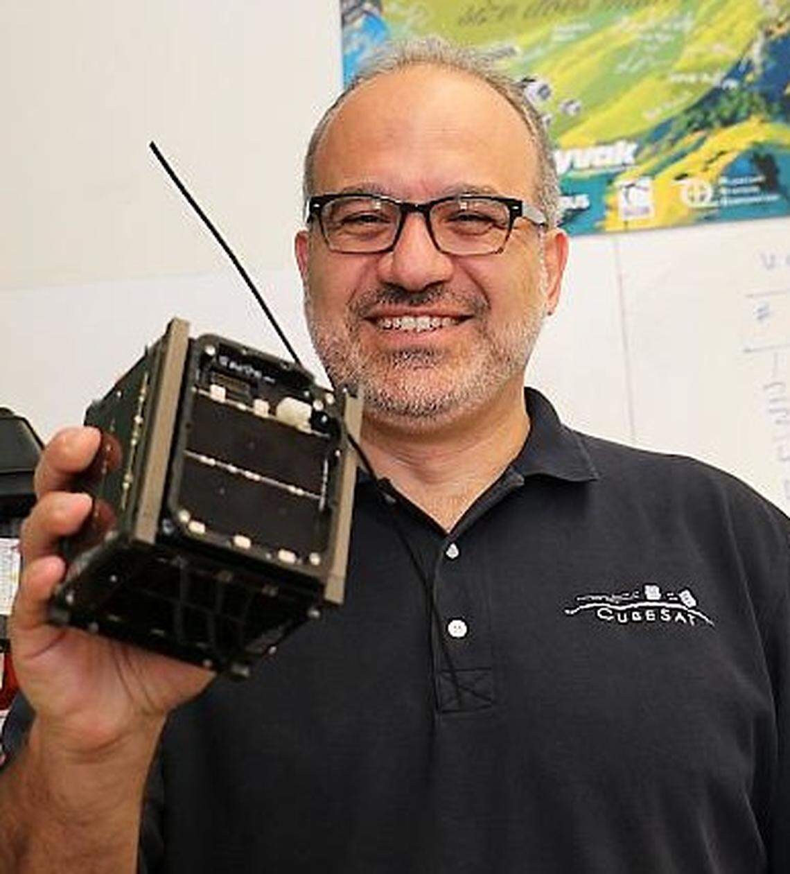 Jordi Puig-Suari, a now-retired Cal Poly aerospace engineering professor, co-created the CubeSat platform, a mini satellite that has greatly expanded space exploration and research for students and increasingly the space industry. Puig-Suari holds a 1U CubeSat, a mini satellite that is a 4-inch cube.