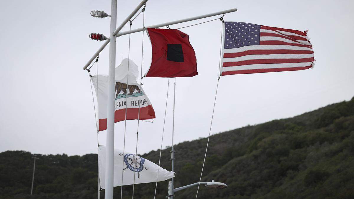 Winds picked up at Port San Luis as storm blows flags at the harbor district office on Dec. 23, 2025.