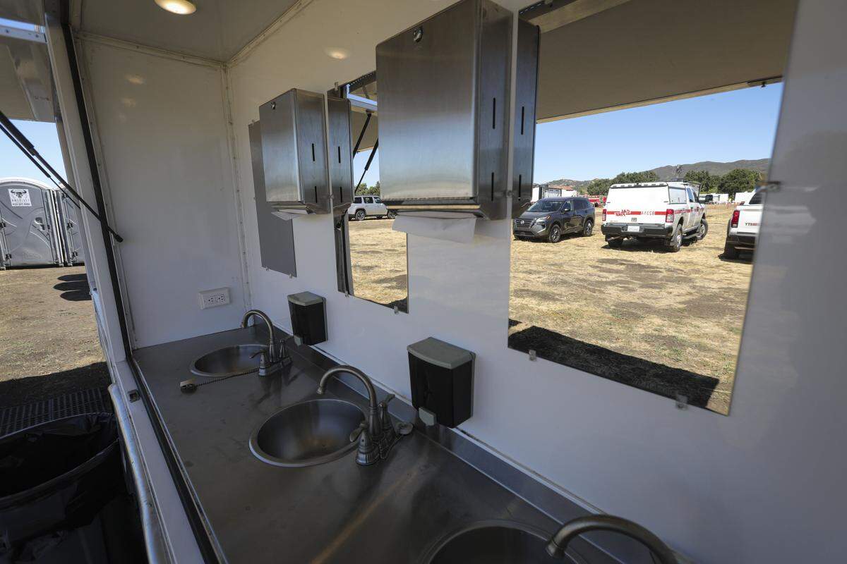 The Santa Margarita Fire Camp includes handwashing stations with mirrors so the firefighters have a place to shave, seen here on Aug. 7, 2025.