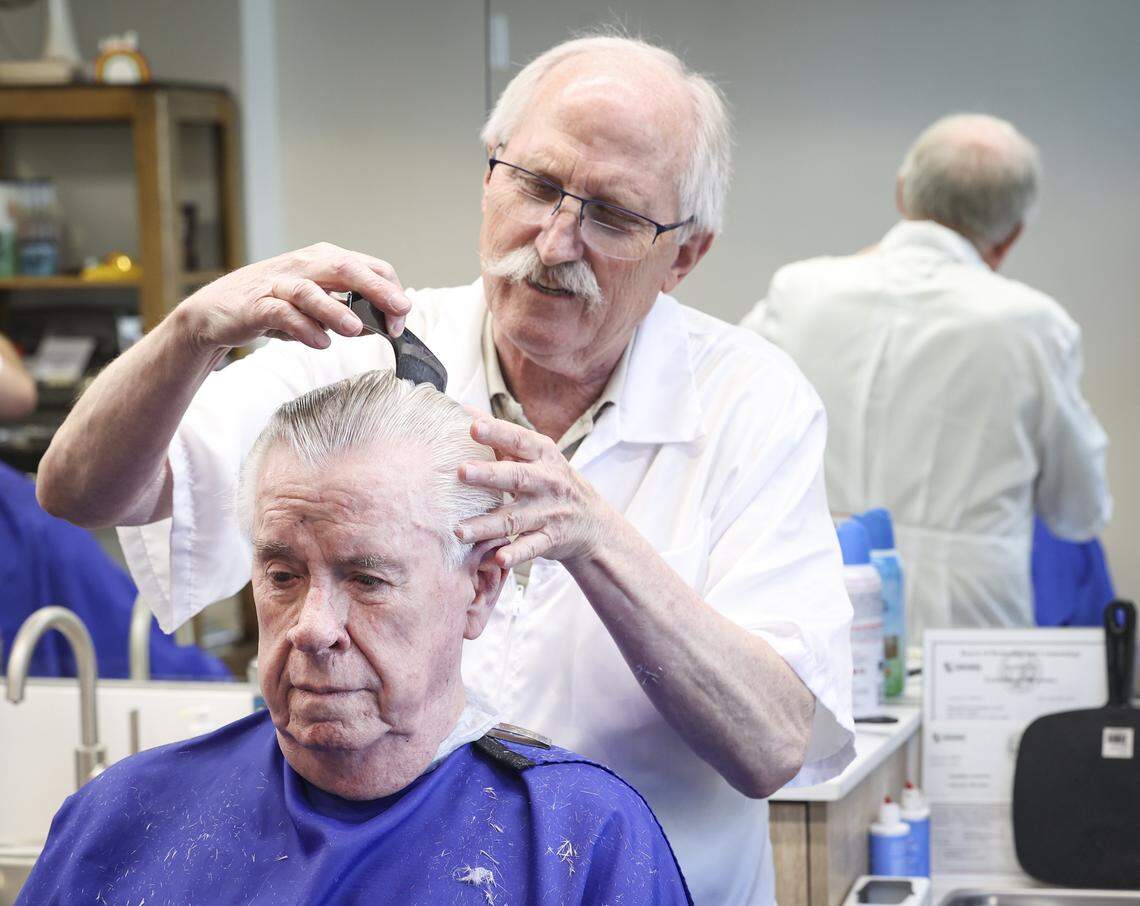 Barber Ray Shearer swaps stories with Terry O’Farrell. The Anderson Barber Shop has moved back to its original location on Monterey Street seen here on April 7, 2026.