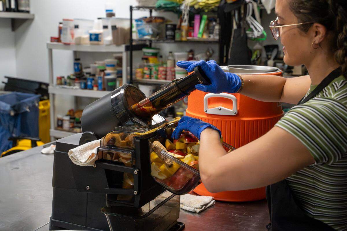SLO Pressed owner Briana Medvecki grinds up apples and lemons in the kitchen at CaliPaso in San Luis Obispo on Thursday, May 14, 2026. Medvecki started pressing juice in 2025 as a way to treat acne and other skin irritations.