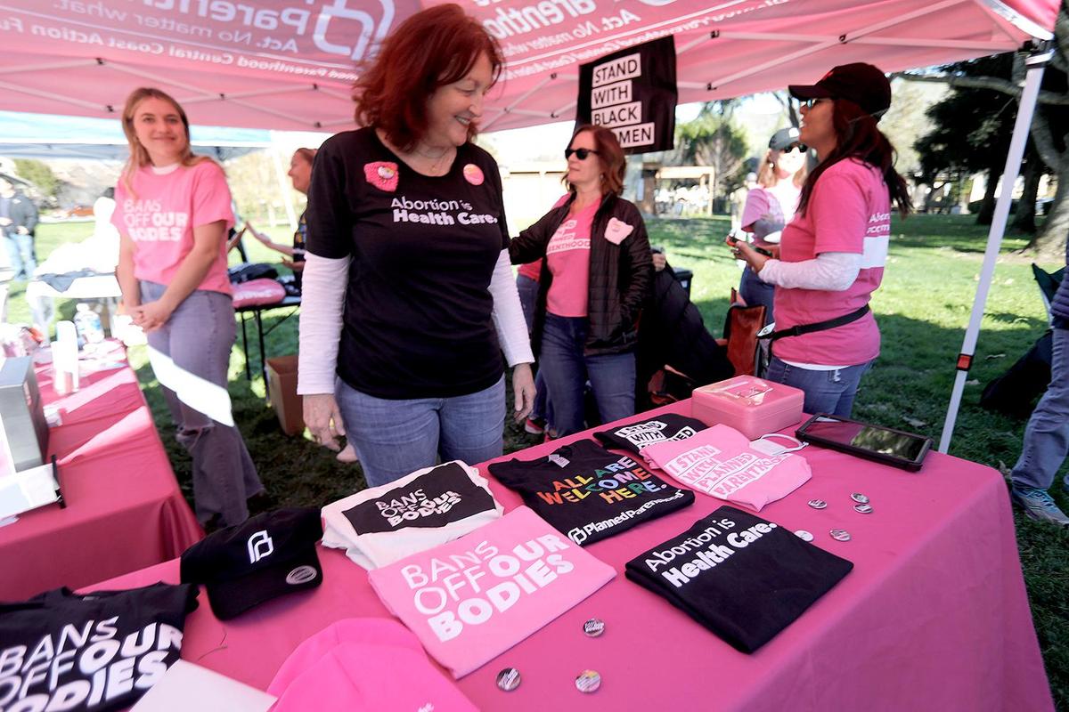 Judy Fox, a volunteer with Planned Parenthood of San Luis Obispo, mans the Planned Parenthood booth at the Women’s March, held in Mitchell Park, Jan. 21, 2023, in San Luis Obispo.