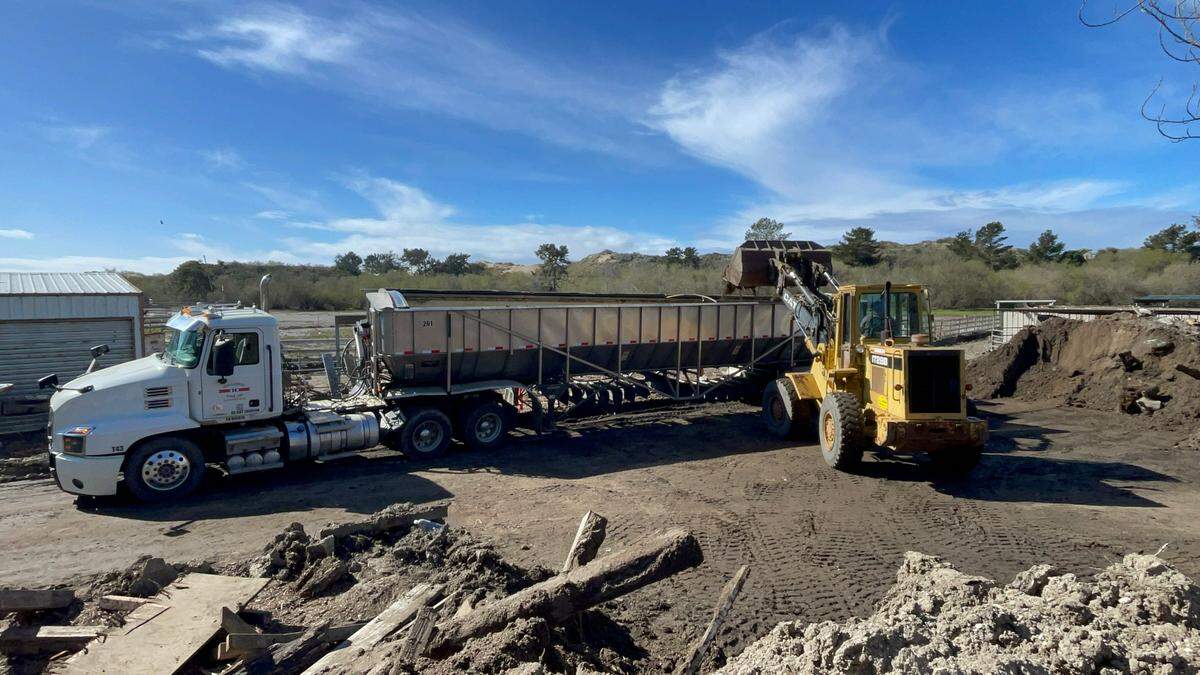 A wheel loader shoveling debris into a semi truck on Feb. 11, 2023.