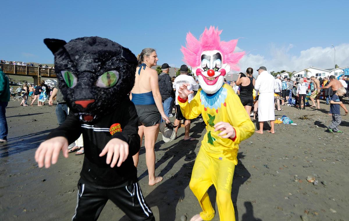 Jamison Perez, 9, and Mason Meazelle-Perez, of Paso Robles don a scary cat and clown costumes. The 43rd Carlin Soule Memorial Polar Bear Dip invites community members to don swimsuits and silly costumes before welcoming the new year by running into the waves.