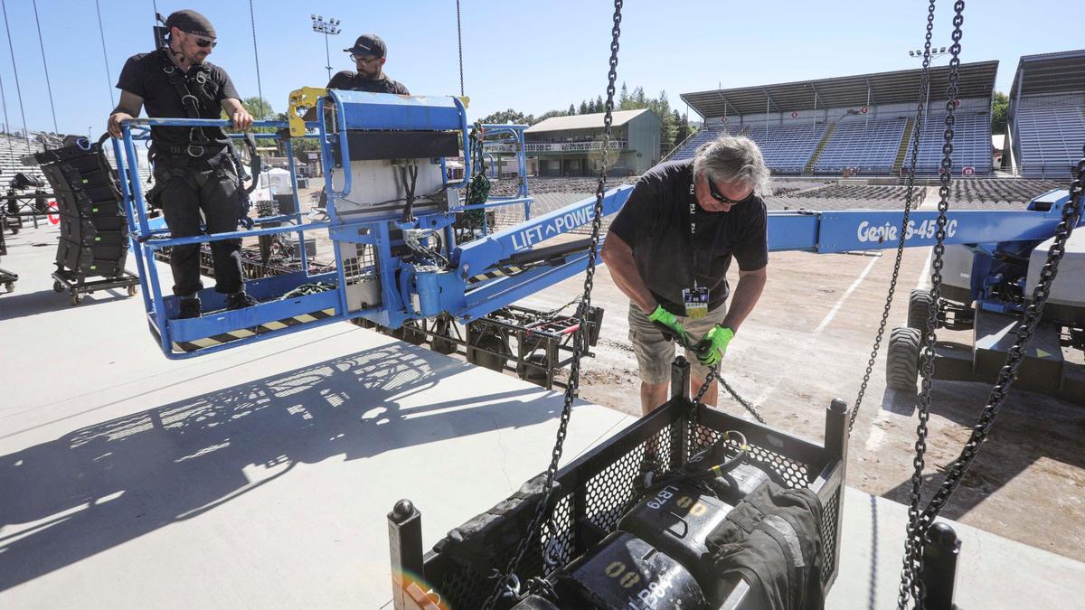 From left, Frithjof Hackey, Robert Pearcy and David Bennett work on the lighting at the Chumash Main Grandstand Arena on Monday, July 15, 2024, ahead of the California Mid-State Fair’s opening on Wednesday.
